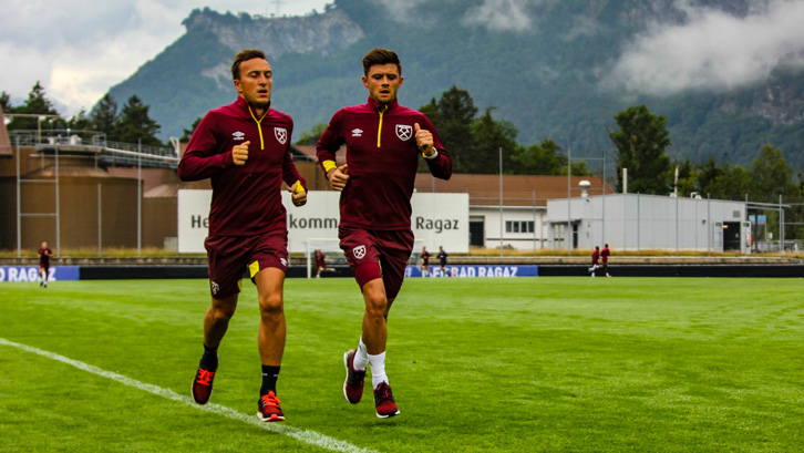 Aaron Cresswell runs alongside Mark Noble during pre-season training in Switzerland